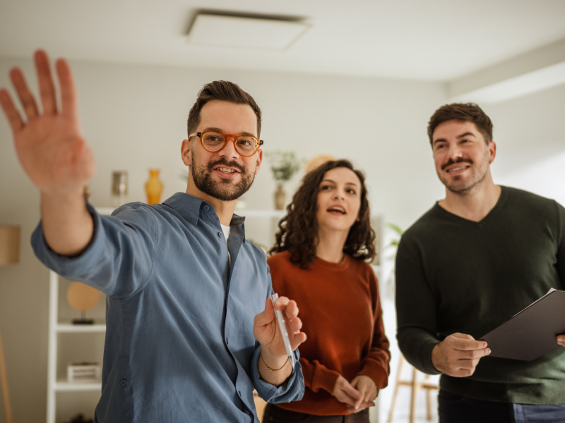 Un couple visite un appartement avec un propriétaire et discute des différentes pièces.